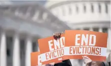  ?? STEFANI REYNOLDS/THE NEW YORK TIMES ?? Activists hold “end evictions” signs Sept. 21 on Capitol Hill in Washington.