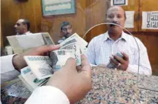  ?? — Reuters ?? An employee counts Egyptian pounds in a bank in Cairo, Egypt.