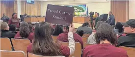  ?? RORY LINNANE/MILWAUKEE JOURNAL SENTINEL ?? Carmen families and staff wear school shirts at a Milwaukee School Board meeting April 23 to signal they don't want to leave their current buildings.