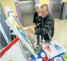  ?? JULIE JOCSAK/STANDARD STAFF ?? Artist Helen Michlik watches as Ken Parker makes his mark during Michlik's event for Culture Days at the Walker Family Cancer Centre. Patients and the public are welcome to make their mark at the Leave Your Mark: A Community Painting Project. The idea...