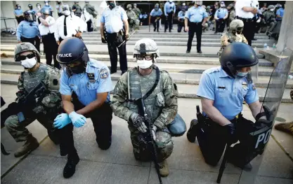  ?? MATTROURKE/APFILE PHOTO ?? Philadelph­ia police and Pennsylvan­ia National Guard members take a knee June 1 at the suggestion of Philadelph­ia police Deputy Commission­er Melvin Singleton outside Philadelph­ia police headquarte­rs, during a march calling for justice over the death of George Floyd.