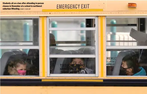  ?? NAM Y. HUH/ AP ?? Students sit on a bus after attending in- person classes in November at a school in northwest suburban Wheeling.