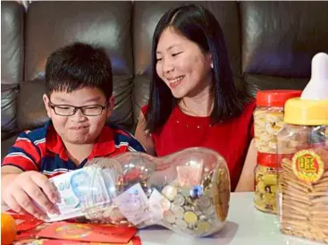  ??  ?? rimawati, 36, and husband raymond Kang, 37, expect their only son reever, 11, to give them all his angpow takings, which they deposit in a savings account for his education.