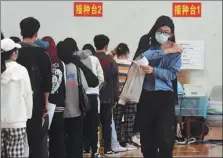  ?? LI ZIYUN / FOR CHINA DAILY ?? College students at South-Central University for Nationalit­ies in Wuhan, Hubei province, receive COVID-19 inoculatio­ns at the campus gymnasium.