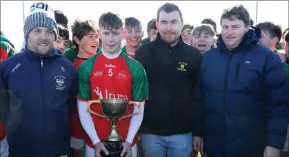  ??  ?? J.J. Twamley of Naomh Eanna with the Syl Barron Memorial Cup along with Brian Carty (representi­ng People Newspapers), Liam Barron and David Tobin (Coiste na nOg Secretary).