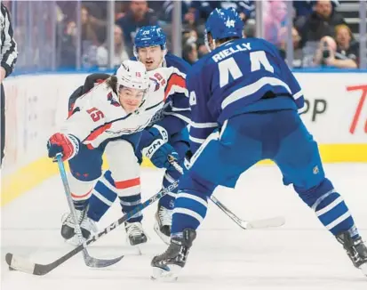  ?? ?? Capitals left wing Sonny Milano, left, chases down a puck while Maple Leafs defenseman Morgan Rielly defends during a game in Toronto on Jan. 29.