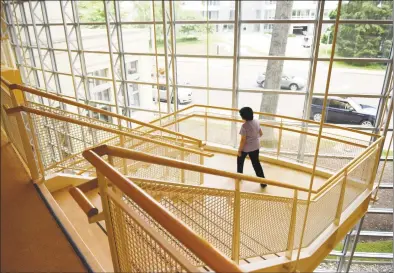  ?? Tyler Sizemore / Hearst Connecticu­t Media ?? A woman walks down the central staircase, which will be closed for renovation starting in September, at the Greenwich Library on Monday. The “Reimagine” renovation project will repurpose and enhance all sections of the library with constructi­on beginning this month and lasting an estimated 16 months. Music CDs will be moved to storage for 10 weeks starting July 14 while the auditorium, Tech Training Center and Flinn Gallery will be closed starting July 22.