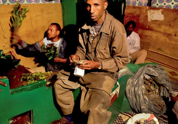  ??  ?? Un négociant du marché de nuit d’Hargeisa compte sa recette. Le marché du qat est juteux. Il sert, entre autres, au financemen­t des milices somalienne­s. Pourtant, comme partout en Afrique, l’argent liquide tend à disparaîtr­e et à laisser place à des...