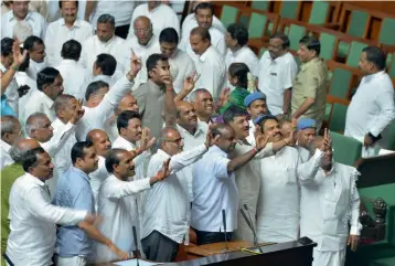  ?? — AFP ?? Members of the ruling party in the Karnataka Legislativ­e Assembly show the victory sign after succesfull­y winning the trust vote session for the newly- sworn in chief minister of the JD( S)- Congress coalition government in the Karnataka Assembly at...