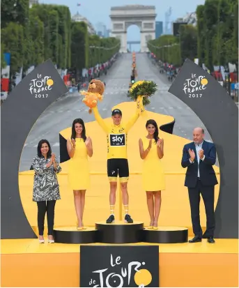  ??  ?? Chris Froome, portant le maillot jaune, savoure une fois de plus le triomphe ultime devant l’Arc de Triomphe, à Paris. - Associated Press: Franck Faugere