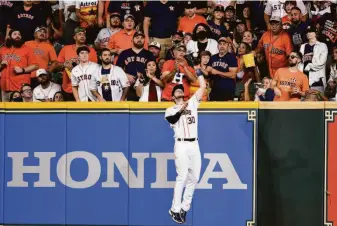  ?? Eric Christian Smith / Associated Press ?? Astros right fielder Kyle Tucker leaps to catch Tony Kemp’s flyball in the sixth inning.