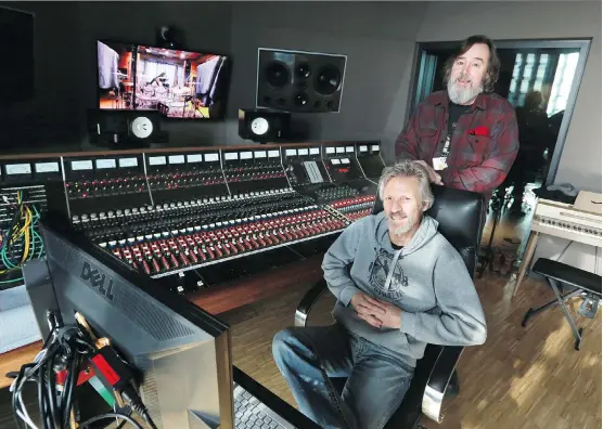  ?? PHOTOS: GAVIN YOUNG ?? Don Schmid, seated, and Jay Semko of The Northern Pikes take a break from recording Tuesday at the historic Trident A Range console in Control Room A at Studio Bell. Members of the band were spending 10 days recording their new album in the studio,...