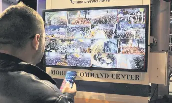  ?? ?? A man stands in front of a monitor showing surveillan­ce camera feeds in Tel Aviv during a protest against controvers­ial government plans to give lawmakers more control of the judicial system.