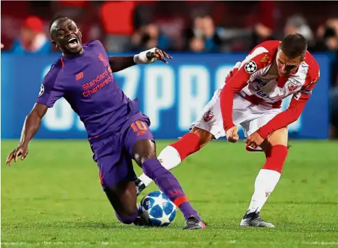  ??  ?? That’s not cool: Liverpool midfielder Sadio Mane (left) is fouled by a Red Star Belgrade player during the Champions League Group C match at the Rajko Mitic Stadium on Tuesday. — AFP