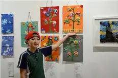  ??  ?? 艺美小学学生与自己小­组的作品合影