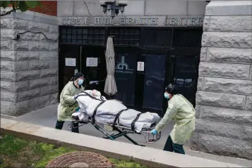  ?? ASSOCIATED PRESS ?? IN THIS APRIL 17 FILE PHOTO, a patient is wheeled out of the Cobble Hill Health Center by emergency medical workers in the Brooklyn borough of New York. The facility has listed dozens of deaths linked to the COVID-19 coronaviru­s pandemic. In New York state, the nation’s leader in nursing home deaths, the Greater New York Hospital Associatio­n lobbying group wrote the first draft of an emergency declaratio­n making it the only state with protection from both civil lawsuits and criminal prosecutio­n arising from the pandemic, with the order signed by Democratic Gov. Andrew Cuomo.