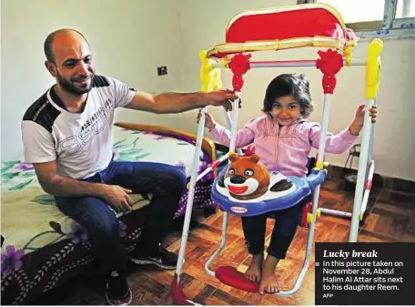  ?? AFP ?? Lucky break In this picture taken on November 28, Abdul Halim Al Attar sits next to his daughter Reem.