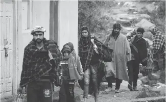  ??  ?? Refugees arrive at a community relief camp on Friday, carrying personal belongings. Hundreds fled their homes at Chhajla village in India’s Mendhar near the border with Pakistan.