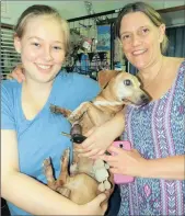  ??  ?? Jessica and Heidi Brown are reunited with their dog, Caramel.