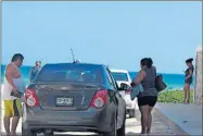  ??  ?? Visitantes estacionan sus vehículos en la calle 58 del oriente del malecón de Progreso, donde no se pusieron vallas para restringir el paso de automotore­s. A la izquierda, un acceso a la playa rescatado