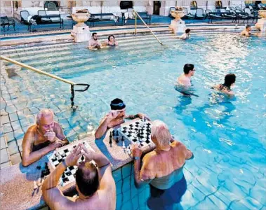  ?? CAMERON HEWITT/RICK STEVES’ EUROPE ?? At Budapest’s Szechenyi Baths, chessboard­s provide a diversion for players standing in chest-high water.