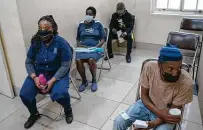  ?? Joao Silva / New York Times ?? People wait to receive a COVID-19 vaccine in Johannesbu­rg on Tuesday as cases rapidly rise in South Africa.