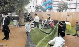  ?? AMIR LEVY/GETTY ?? Ultra-Orthodox Jews build an outdoor synagogue Thursday in Bnei Brak, Israel, ahead of a three-week coronaviru­s lockdown. The second nationwide lockdown begins Friday.