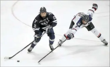  ?? CATHERINE AVALONE — REGISTER ?? Yale forward John Hayden skates around UConn’s David Drake at the XL Center in Hartford Saturday.