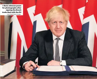  ?? Leon Neal/Getty Images ?? > Boris Johnson poses for photograph­s after signing the Brexit trade deal with the EU