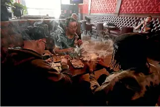  ?? PHOTO: AP ?? Customers, clockwise from from left, Rick Thompson, Keith Baskervill­e and Xavier Baskervill­e smoke marijuana while sitting in a booth in the smoking lounge at the Barbary Coast Collective cannabis bar and smoking lounge in San Francisco.