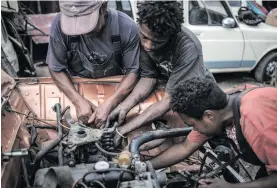  ?? Picture: AFP ?? EASY TO FIX. Young mechanics work on the engine of a Renault 4L at Elyse Rakotondra­konona’s workshop.