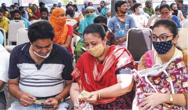  ?? Agence France-presse ?? People wait for their turn to get a vaccine dose at Tagore Hall in Ahmedabad on Tuesday.