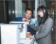  ?? PROVIDED TO CHINA DAILY ?? A Truliva employee (left) shows a consumer how to operate a water purificati­on product in Beijing.