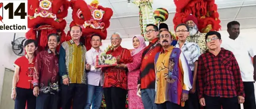  ??  ?? Gear up for election Prosperous gift: Ahmad Husni (centre) after receiving a tray with items symbolisin­g good luck and fortune from lion dancers during a Chinese New Year open house in Tanjung Rambutan. With him are various local community leaders.