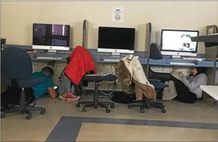  ?? PHOTO COURTESY THE UC TANGERINE ?? Utica College students hide under desks after being instructed to shelter in place on Monday, March 5, 2018, after the college went into lock down following a “real, credible threat.”