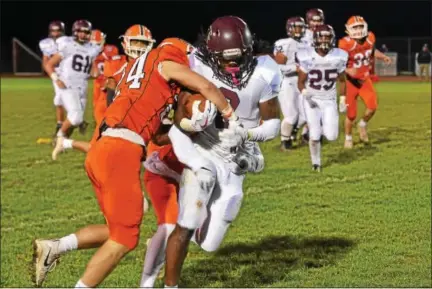  ?? SAM STEWART - DIGITAL FIRST MEDIA ?? Above, Perkiomen Valley’s Brendan Schimpf (24) strips the ball from the grasp of Pottsgrove’s Rahsul Faison Friday. Below, Perkiomen Valley’s Alec Jackon (5) and Schimpf (24) raise the PAC championsh­ip plaque after defeating Pottsgrove in the title game Friday.