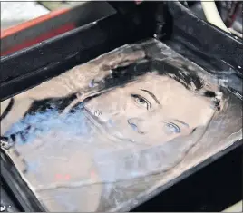  ??  ?? The image of Williams appears as the glass photo plate is bathed in a fixer.