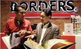  ?? ZULFADHLI ZAKI/ THESUN ?? At the launch ... Hishammudi­n (left) and Chan sharing a light moment at the newly renovated Borders The Gardens. (below) Hishammudi­n showing Chan the Starbucks coffee bar within the bookstore, with Radioshack’s corner in the background.