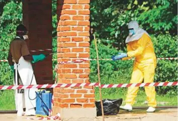  ?? Reuters ?? A health worker is sprayed with chlorine after visiting the isolation ward at Bikoro hospital, which received a new suspected Ebola case, in Bikoro, Democratic Republic of Congo.