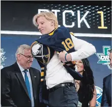  ?? MICHAEL AINSWORTH THE ASSOCIATED PRESS ?? Rasmus Dahlin puts on a jersey after being selected by the Buffalo Sabres first overall in Friday’s NHL draft.