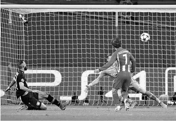  ?? - AFP photo ?? Atletico Madrid’s French forward Antoine Griezmann (R) scores the 0-2 goal past Leverkusen’s goalkeeper Bernd Leno during the UEFA Champions League round of 16 first-leg football match between Bayer 04 Leverkusen and Club Atletico de Madrid in...