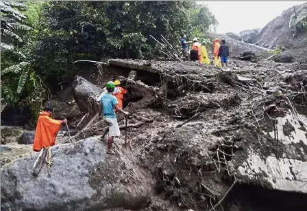  ?? — AP ?? Moving mountain: Rescuers digging through earth searching for survivors after a massive landslide in Natonin township, Mountain Province.