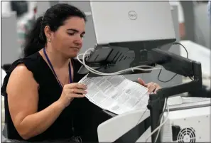  ?? (File Photo/ap/lynne Sladky) ?? A worker organizes vote-by-mail ballots for scanning Nov. 8 during the midterm election at the Miami-dade County Elections Department in Miami. Stories circulatin­g online incorrectl­y claim Florida’s ability to report election results quickly during the 2022 midterms means states that have taken longer, such as Arizona and Nevada, are engaged in fraud.