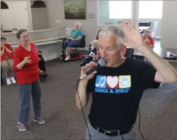  ?? REBECCA SLEZAK — THE DALLAS MORNING NEWS ?? Susan Norris dances as Eric Kolb, a founder of the nonprofit Songs&Smiles, spins while singing with residents on Tuesday at Villagio of Carrollton in Carrollton, Texas. Those in attendance danced and sang along to popular 1960s-era songs. Kolb has visited the residents to sing twice a month over the last year