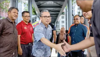  ?? ?? Fahmi (third left) arriving for the ‘Back to School’ programme with the MCMC and Shopee at PPR Sri Pantai. — Bernama photo