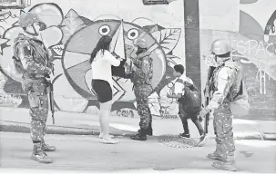  ?? — Gambar AFP ?? PERIKSA: Anggota tentera Brazil memeriksa penduduk di favela Chapeu Mangueira ketika operasi memburu kumpulan samseng di Rio de Janeiro kelmarin.