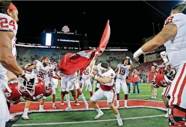  ?? [PHOTO BY KYLE ROBERTSON, THE COLUMBUS DISPATCH] ?? Baker Mayfield (6) plants the Sooner flag in the Ohio State logo at midfield after beating the Buckeyes 31-16 at Ohio Stadium on Saturday night.