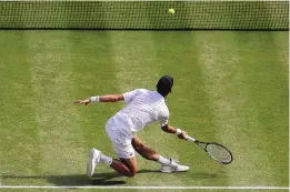  ?? PETE NICHOLS/ASSOCIATED PRESS ?? Novak Djokovic goes low to return a shot from Italy’s Matteo Berrettini during Sunday’s Wimbledon men’s final. Djokovic won in four sets.