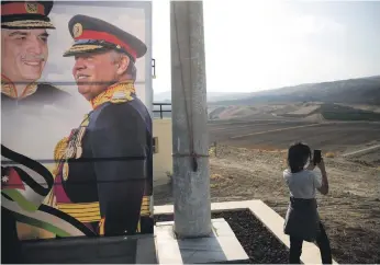  ?? Reuters ?? An image of Jordanian King Abdullah and his father King Hussein at the ‘Island of Peace’ on the Jordanian side of the border with Israel, in the area that has been reclaimed by Amman