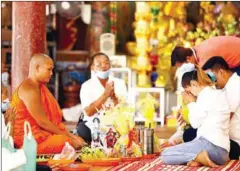  ?? HONG MENEA ?? Buddhists offer alms to a monk during Visak Bochea Day at Wat Sansam Kosal in Phnom Penh’s Meanchey district in 2020.